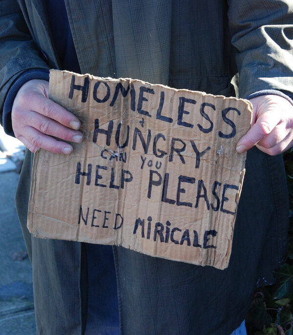homeless man holding sign asking for help