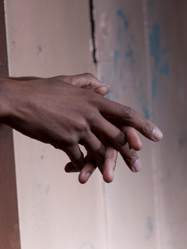hands of an african-american man held out through prison bars