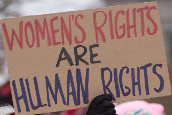 hand holding up sign saying women's rights are human rights