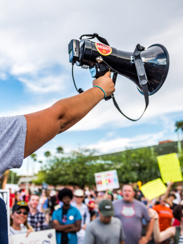 Student holding up a megaphone in front of a crowd