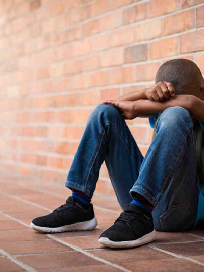 A Black student with his head between his hands