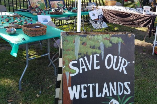 Informational table with a sign that reads "Save our Wetlands"