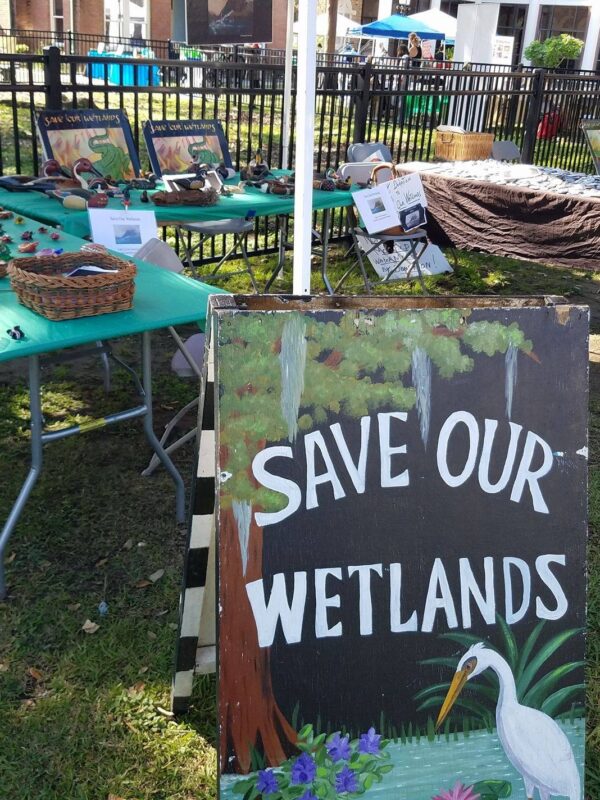 Informational table with a sign that reads "Save our Wetlands"