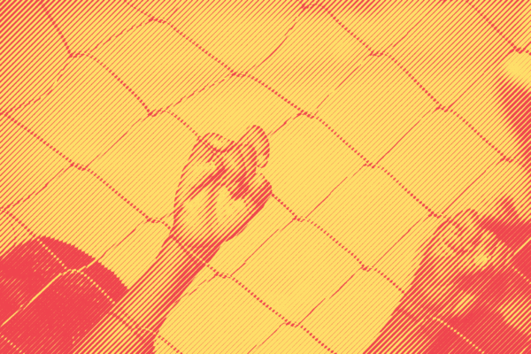 A child's hand on a chain link fence