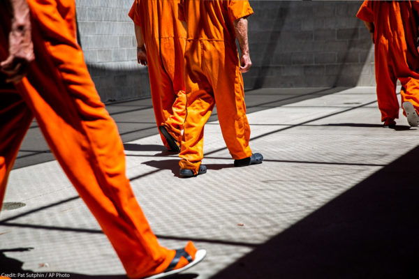 Image of people wearing prison orange jumpsuits