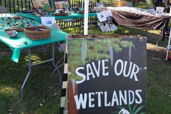 Informational table with a sign reading Save our Wetlands