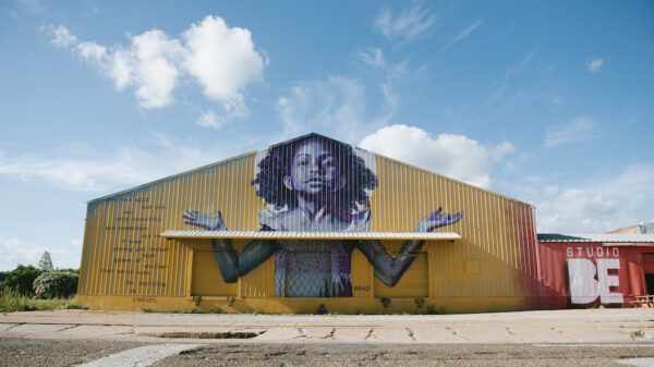 The exterior of BMike's Studio Be, with a mural of a young Black girl with her arms outstretched