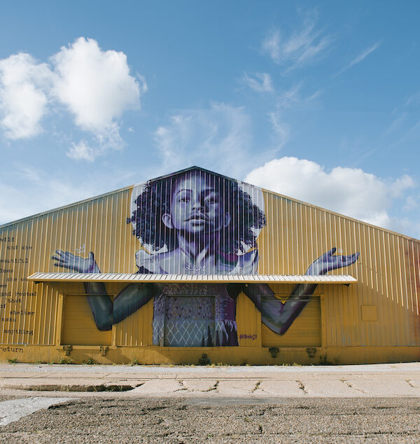 The exterior of BMike's Studio Be, with a mural of a young Black girl with her arms outstretched