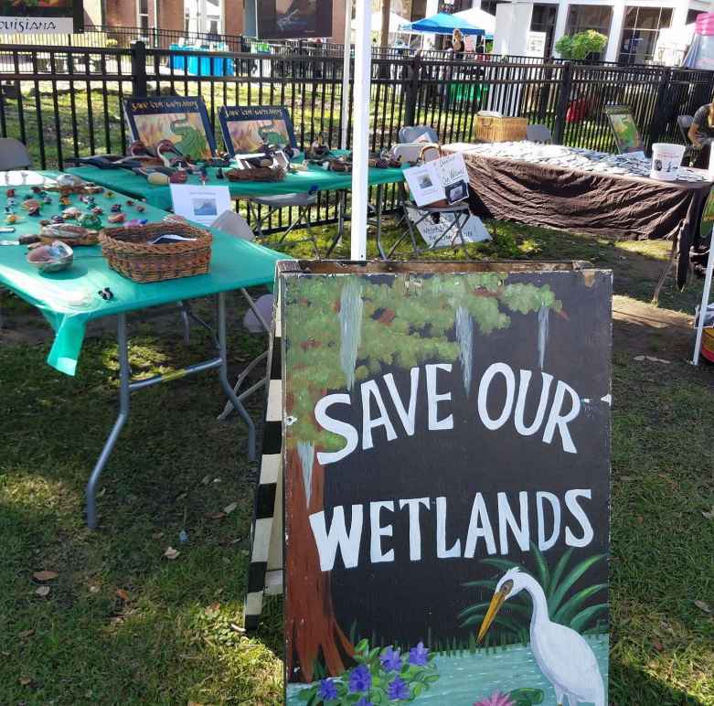 Informational table with a sign reading Save our Wetlands