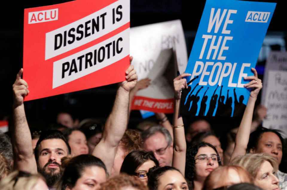 Protesters hold ACLU signs 