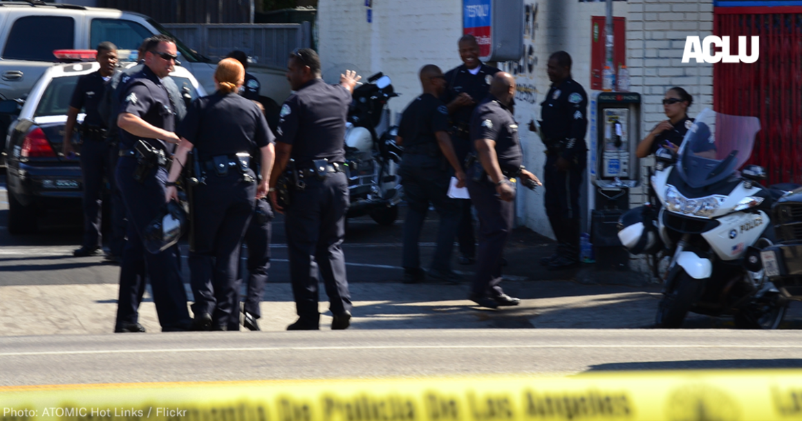 a group of police officers gathers outside a convenience store