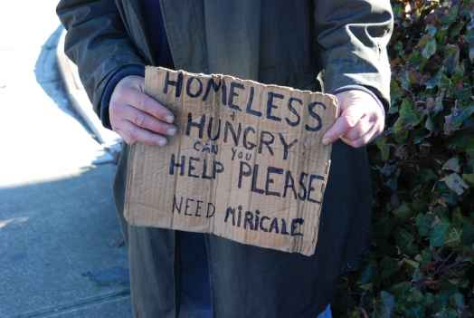 homeless man holding sign asking for help
