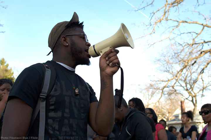 A black man holds a bullhorn at a protest
