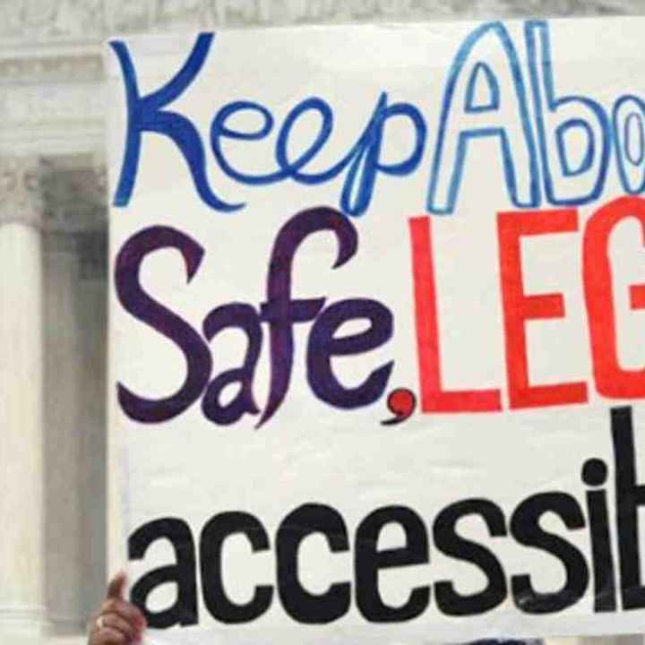 Protest sign reading "Keep abortion safe, legal and accessible"