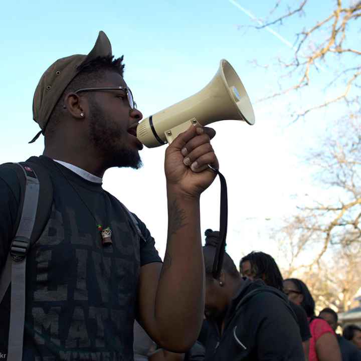 A black man holds a bullhorn at a protest