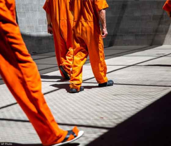 Image of people wearing prison orange jumpsuits